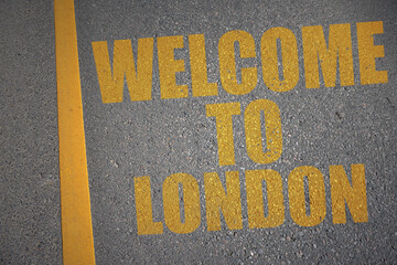asphalt road with text welcome to London near yellow line.