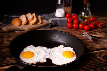 
Fried eggs in a pan. on a wooden background. Breakfast
