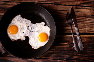 
Fried eggs in a pan. on a wooden background. Breakfast