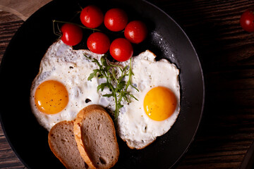 
Fried eggs in a pan. on a wooden background. Breakfast