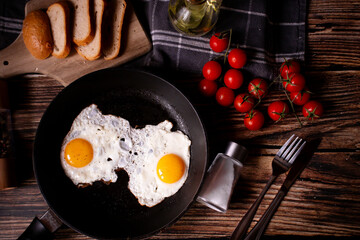 
Fried eggs in a pan. on a wooden background. Breakfast