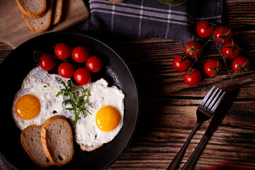 
Fried eggs in a pan. on a wooden background. Breakfast