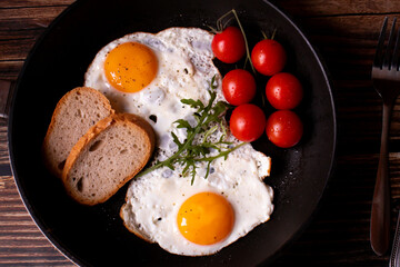 
Fried eggs in a pan. on a wooden background. Breakfast