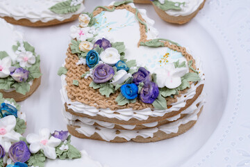 Obraz na płótnie Canvas Heart shaped cookies decorated with royal icing glaze and flowers. Romantic wedding or Valentine’s Day cookies