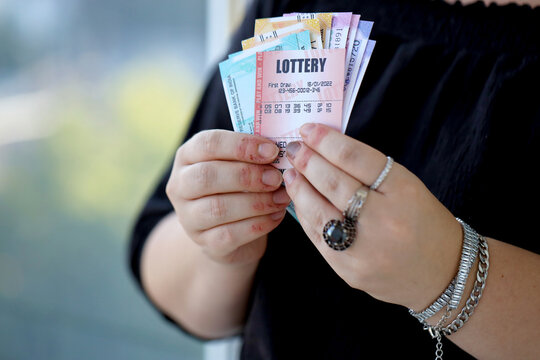 Woman hands with indian rupees bills and lottery ticket close up. Concept of gambling and winning money in indian lottery