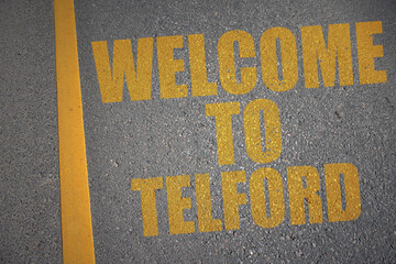 asphalt road with text welcome to Telford near yellow line.