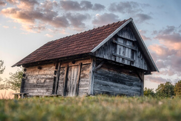 Beautiful sunset in the vineyard of the village with a wooden house