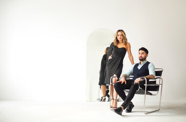 Fototapeta premium Stylish young ethnic couple embracing against light gray wall