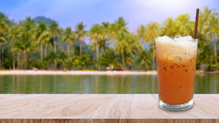 Iced thai milk tea in glass, Milk ice tea, Cheddar is a traditional Thai drink on wooden table with...