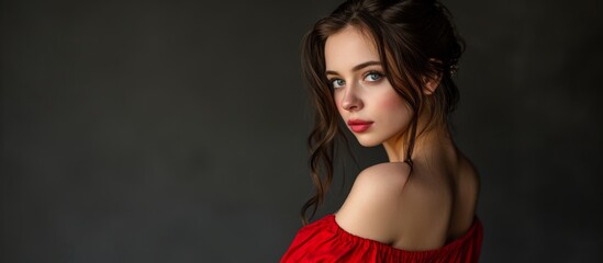 Fototapeta premium Portrait of woman in red dress, looking over left shoulder.