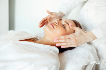 Obraz na płótnie Canvas Crop massage therapist massaging face of client