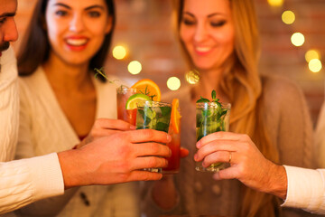 Young men and women drinking cocktail at party