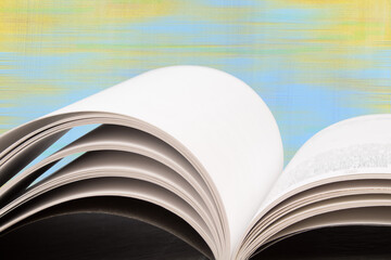 Composition with hardback books, fanned pages on wooden deck table and blue background. Books stacking. Back to school. Copy Space. Education background.