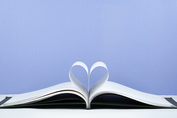 Old open hardback book, page decorate into a heart shape for love in Valentine's. love with open book heart.