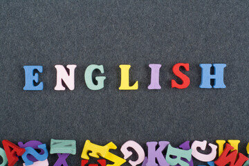 English word on black board background composed from colorful abc alphabet block wooden letters, copy space for ad text. Learning english concept.