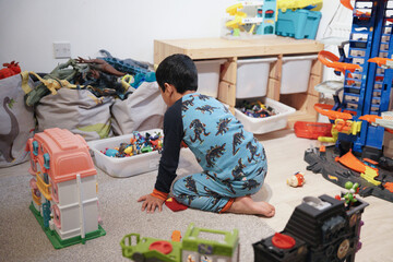 child is playing healthy with toys and enjoying the toys in his own house wearing pyjamas.         ...