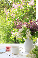 Abstract flower arrangement, home interior with beautiful spring lilac branches in a vase on a sunny window, banner, still life with space for text, floral holiday card,