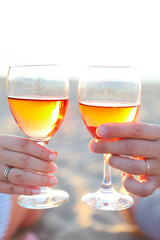 Man and woman with glass of rose wine on beach picnic