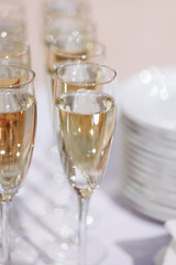 Several glasses of sparkling champagne on a white tablecloth. Celebration or buffet concept. Blurring the bottom of a photo with copy space.