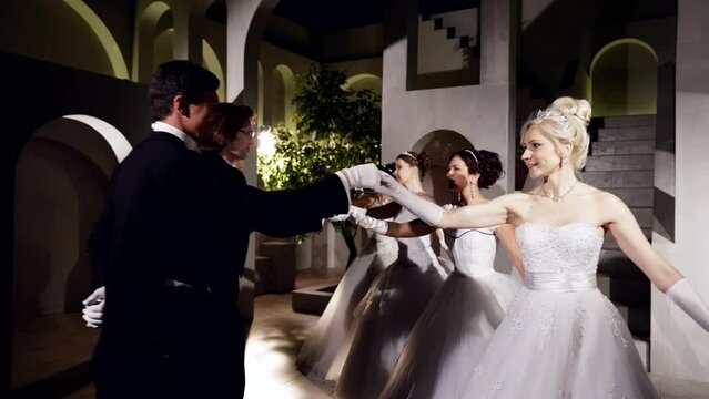 dancers in ballroom of palace in night in traditional Viennese ball, beautiful women and gentlemen