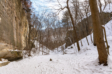 Hiking trail in Ottawa canyon on a brisk winter morning with snow covered landscape.  Starved Rock State Park, Illinois, USA.