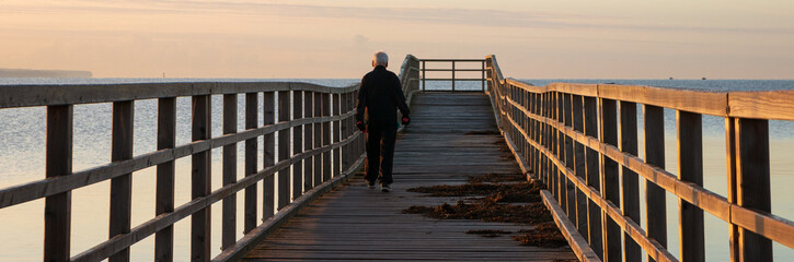 Sportlich aktiver Senior mit Hanteln beim Training am Meer,  gesund im Senioren Alter.
