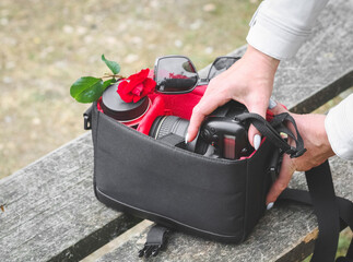 The hands of a Caucasian young unrecognizable woman take out a photograph from her purse.
