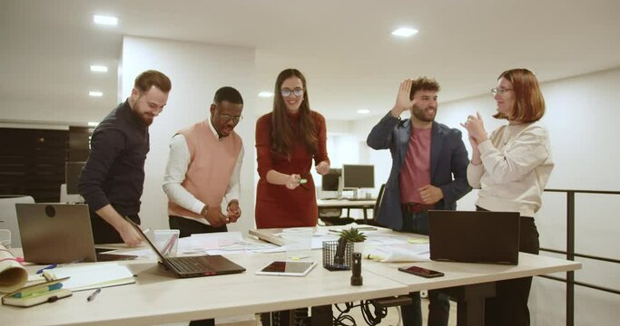 Having met the project deadline, business colleagues find success in its acceptance and timely compensation, sparking celebratory moments among the creative team.