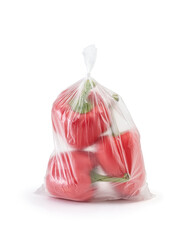 Red sweet bell pepper in a closed transparent plastic bag on a white background. Vertical photo.