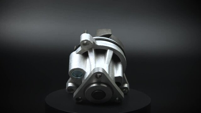 Auto parts car spare parts on a black background. The new ICE water cooling pump rotates on a turntable around its axis. Auto parts store. Engine car details