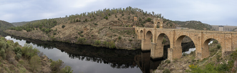 Fototapeta na wymiar Panoramic photograph of the Alcántara Bridge over the Tagus River. An authentic engineering work carried out by the Roman Empire. Alcantara, Caceres, Spain