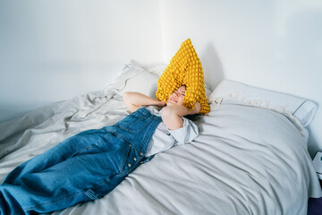 frustrated woman holding pillow over head, screaming feels furious exhausted exasperated laying on...