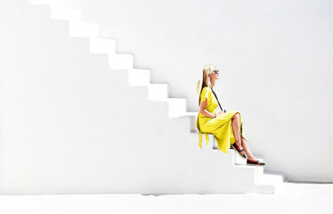 Stylish woman on white stairs in sunlight - obrazy, fototapety, plakaty