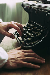 A writer writing a novel, using old vintage typewriter - 717059652