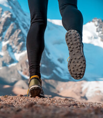 Man is running in the mountains, legs closeup.