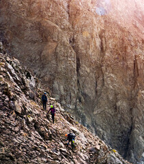 A group of climbers climb to the top of a mountain, peaple are engaged in a mountaineering.