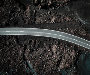 View from above on the road among black basalt rocks and lava formations.