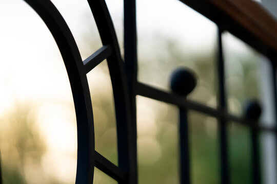 Curved forged modern fence on the balcony closeup.