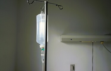 Medizinischer Infusionsbeutel hängt an silberner Metallstange in Krankenzimmer in Klinik