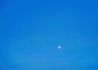 Blaue Himmellandschaft mit weißem Mond bei Frost und Kälte am Nachmittag im Winter