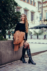 Chica joven con pelo rizado posando en la calle