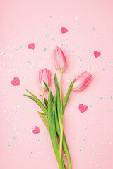 Pink tulips and hearts on background with confetti. Valentines day, womens day concept. Top view, flat lay