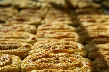 Close-up of golden-baked sesame seed pastries, fresh from the oven, ideal for bakery or culinary...