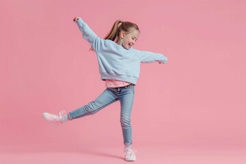 Full length photo of small girl wear stylish sweatshirt jeans raising leg up stand on tiptoe dancing isolated on pink color background - obrazy, fototapety, plakaty