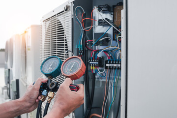 Technician is checking air conditioner,measuring equipment for filling air conditioners.