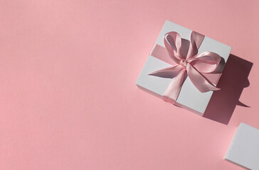 White gift boxes on the pink background. Top view. Copy space