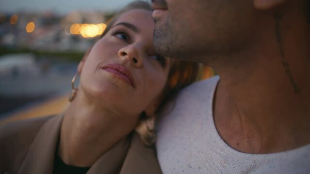 Closeup tender couple kiss lips hug in evening lights. Loving woman look partner