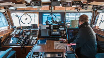 Navigational Bridge of a Modern Military Vessel Featuring Advanced Communication Equipment and Ship Controls