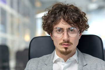 Focused male office worker at his workplace exudes confidence. Displays traits like dedication, expertise, and a thoughtful demeanor.