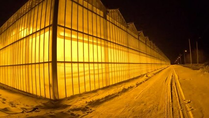 a modern greenhouse taken close up at night in the frosty season of the year